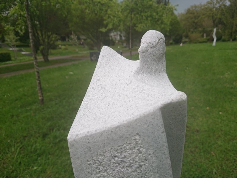 Skulptur aus Stein. Vogel-Motiv im Park, Kunstobjekt. Dekorative Gartengestaltung.