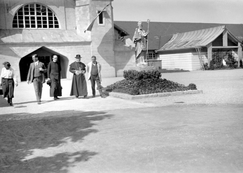 Historisches Foto: Gruppe vor Kirche mit Bischofsstatue. Religiöses Erbe, Architektur.