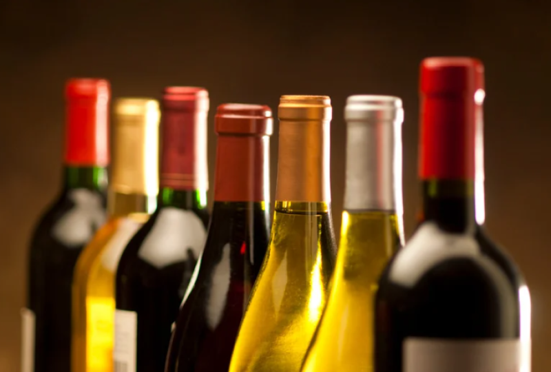 Reihe edler Weinflaschen. Rotwein und Weißwein in Flaschen. Weinprobe und Genuss.