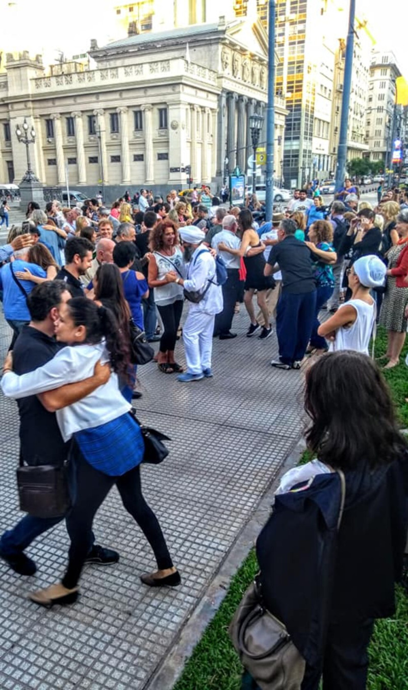 Menschen tanzen Tango auf der Straße vor einem historischen Gebäude. Tango in Buenos Aires, Argentinien.