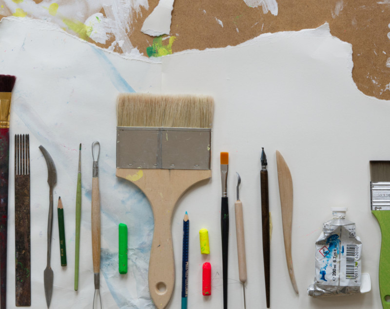 Künstlerbedarf: Pinsel, Farben, Werkzeuge auf einer Leinwand. Kreatives Malen und Zeichnen. Künstlerische Gestaltung.