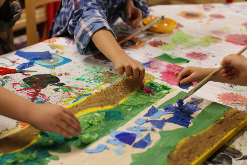 Kinder basteln mit Papier und Farbe an einem Tisch, kreative Kunstprojekte im Kindergarten